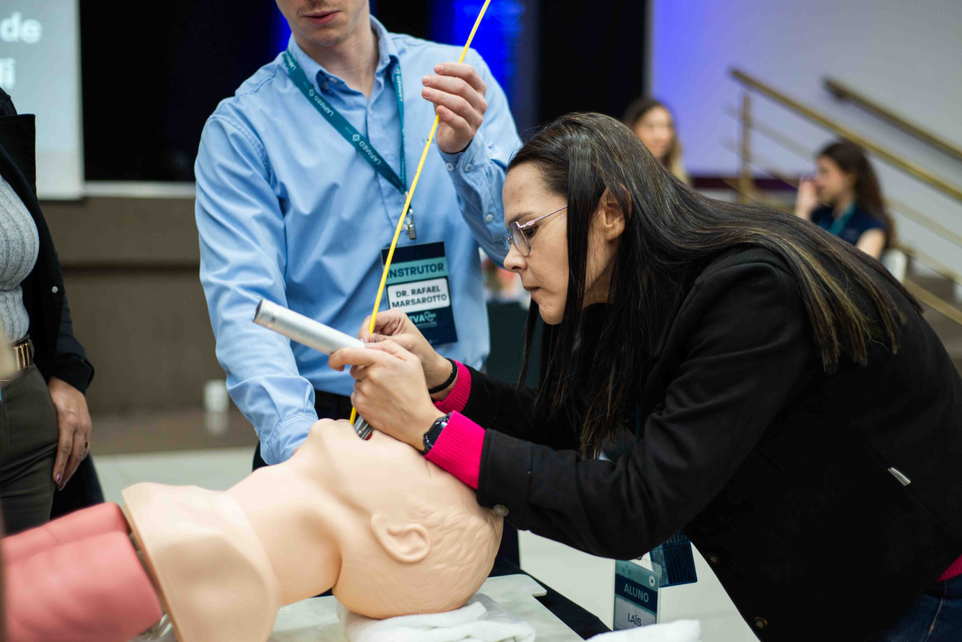 Médica treinando intubação em manequim com acompanhamento do instrutor durante o TVA360